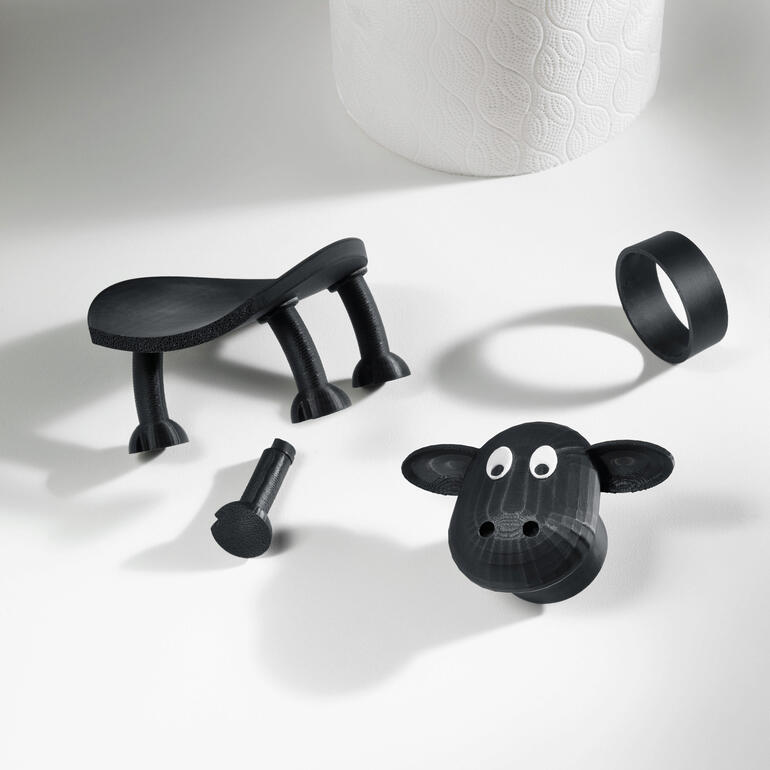 Entièrement fabriqué en Allemagne grâce à l’impression 3D. Pièces séparées d'un porte-rouleau de papier toilette en forme de mouton sur une table.
