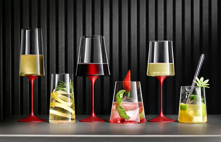 Ensemble de deux verres en cristal avec différentes boissons sur une table.