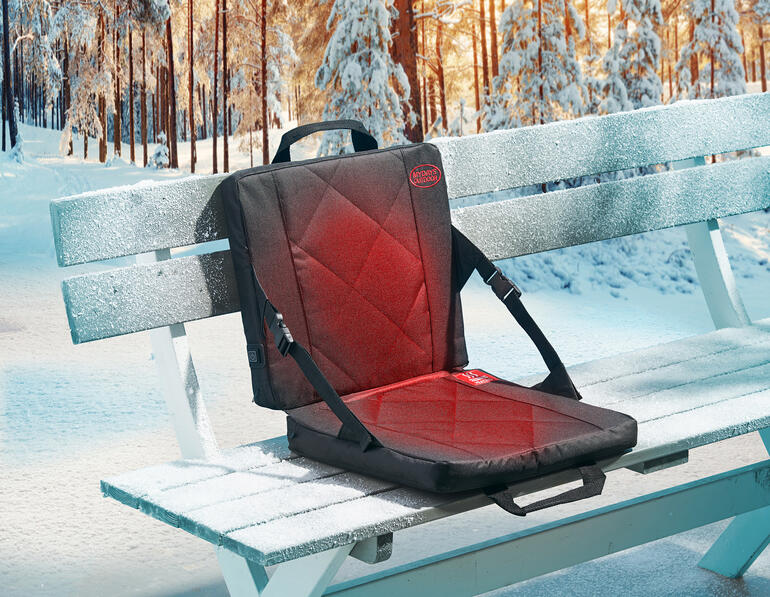 Coussin chauffant sur un banc de parc gelé en hiver.