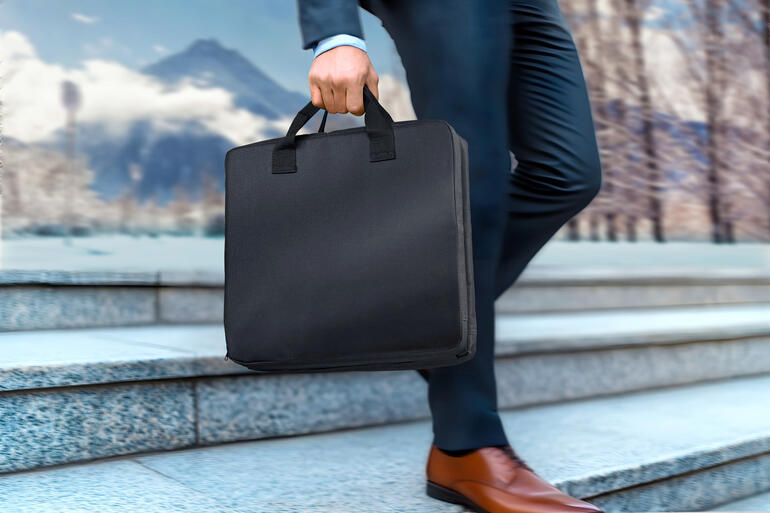 Homme portant un sac noir en marchant dans les escaliers.