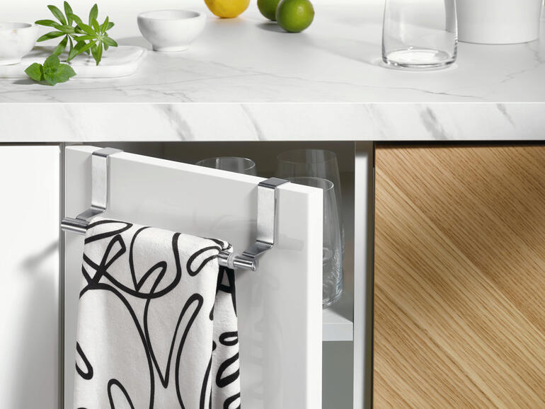 Porte-serviettes extensible avec une serviette sur une porte de cuisine.