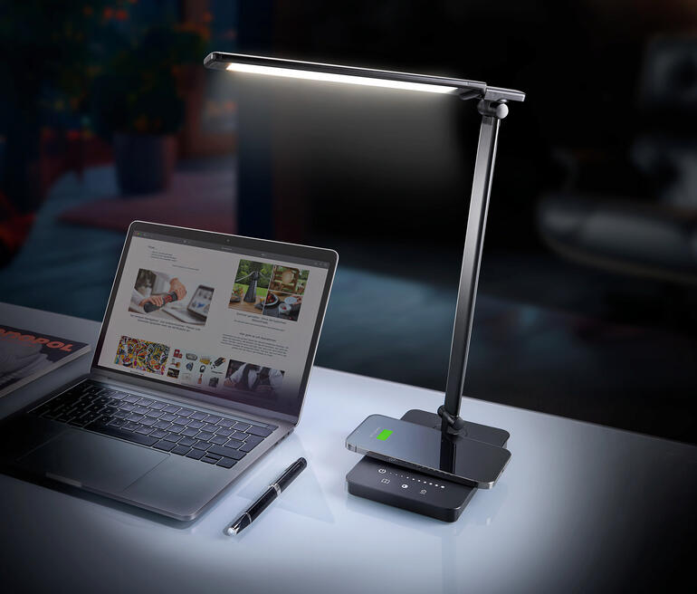 Lampe de bureau LED dynamique sur un bureau à côté d'un ordinateur portable