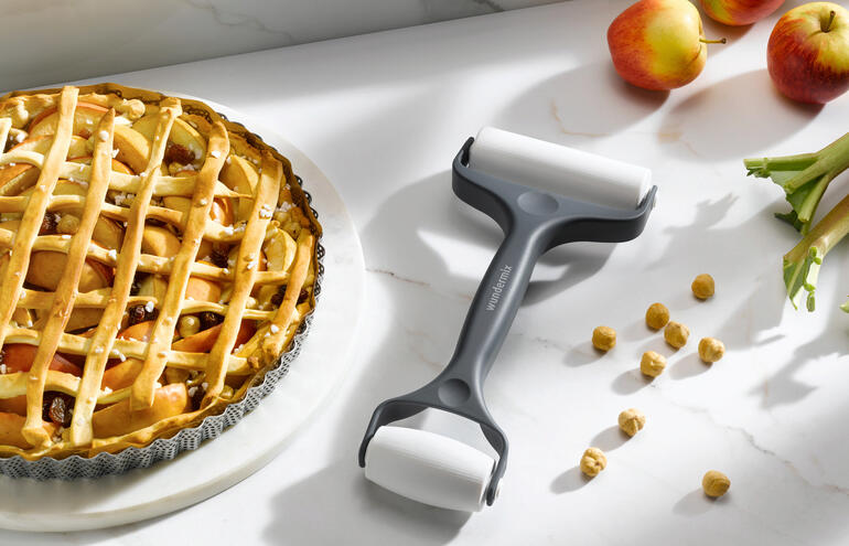 Rouleau à pâtisserie double à côté d'une tarte aux pommes sur une table de cuisine.