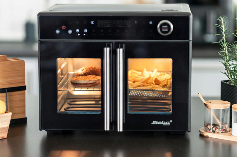 Four à air chaud Tri-Zone avec des portes ouvertes et des frites visibles.