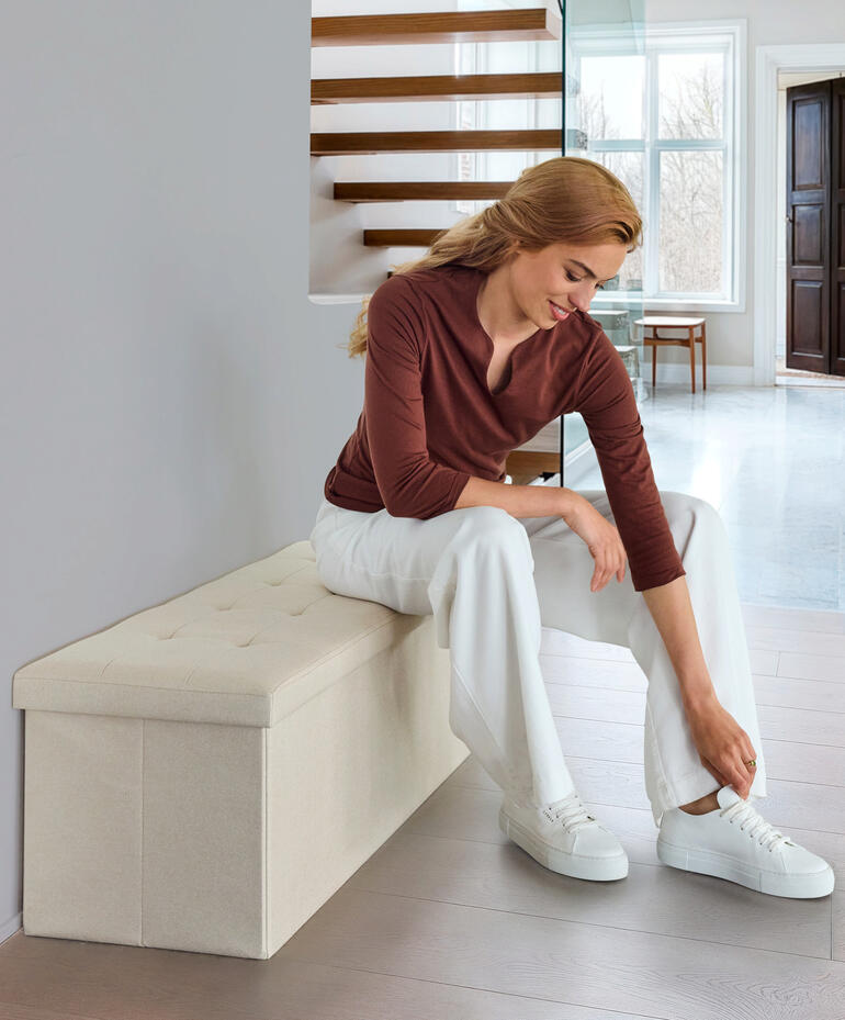 Coffre à siéger pliable en couleur naturelle, utilisé comme siège.
