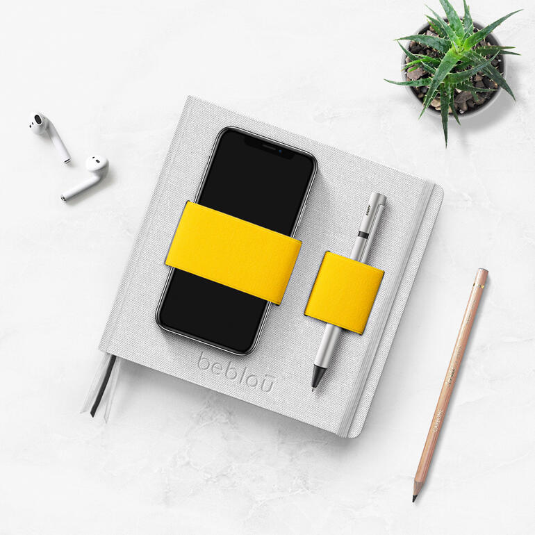 Flex-Book avec smartphone, stylo et plante sur une table.