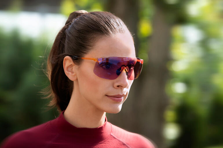 Femme en tenue de sport portant des lunettes de soleil.
