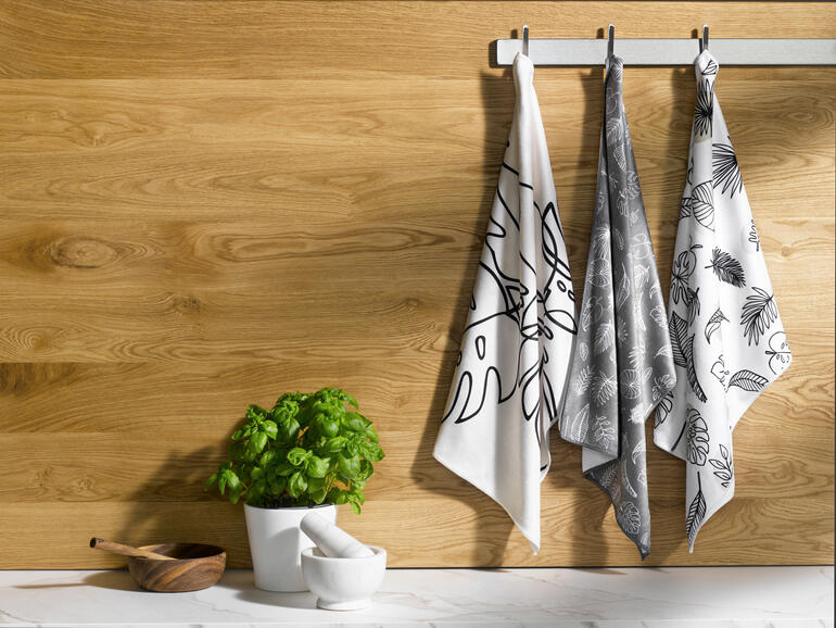 Trois torchons Speed-Dry suspendus à une barre en bois.