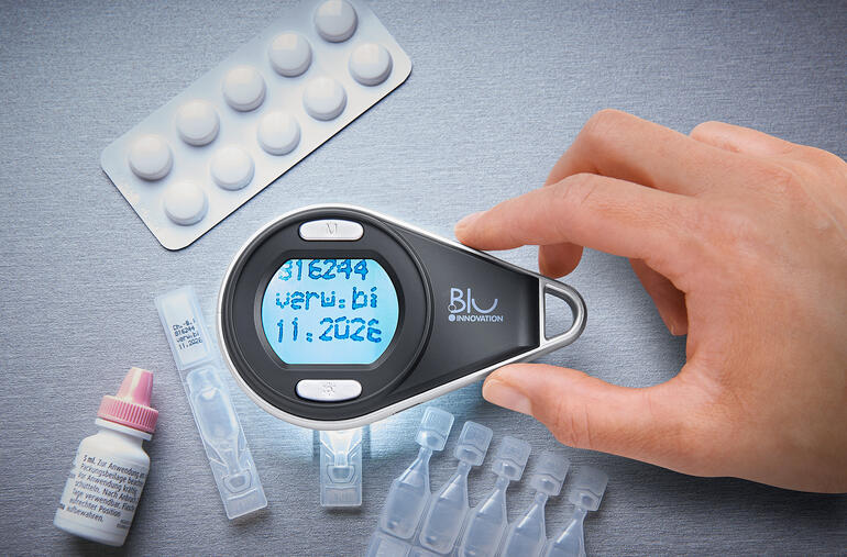 Loupe digitale portable à main, à côté de pilules et de flacons de test.