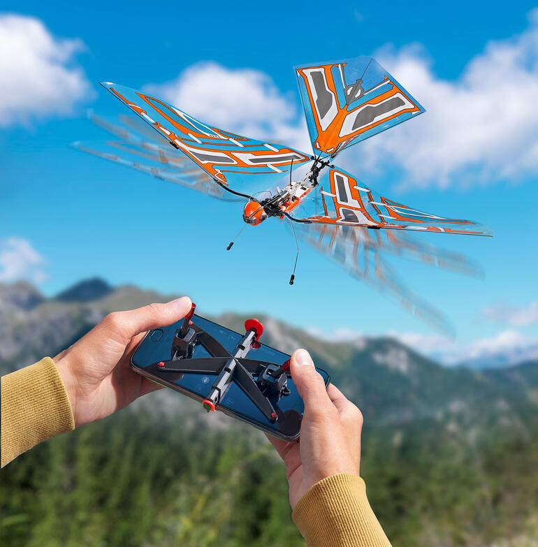 Modèle contrôlé à distance d'un insecte volant avec une structure d'aile orange.