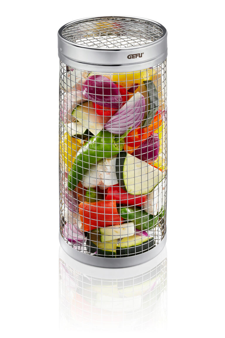 Panier cylindrique pour barbecue Panier de grill cylindrique en métal rempli de légumes colorés sur fond blanc.