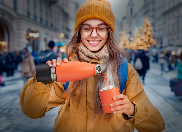 La tasse est simplement intégrée au fond de la bouteille... Femme dans la rue versant d'une bouteille isolante dans un gobelet.