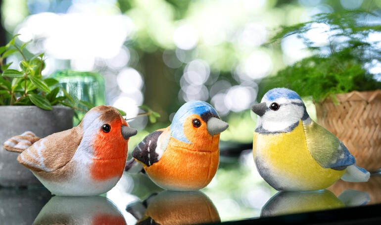 Trois figurines d'oiseaux décoratifs aux couleurs naturelles.