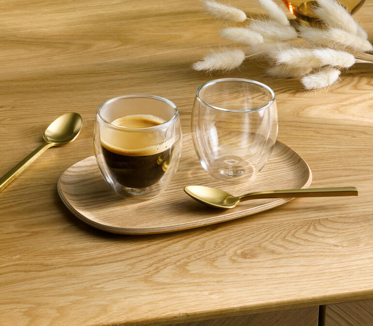 Deux verres thermiques premium sur une planche en bois, l'un contient de l'espresso.