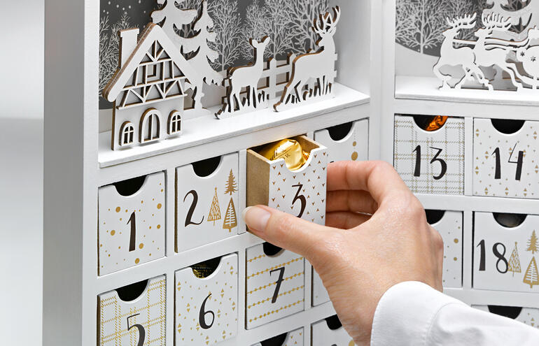 Calendrier de l'Avent avec un design de village d'hiver et une porte ouverte.