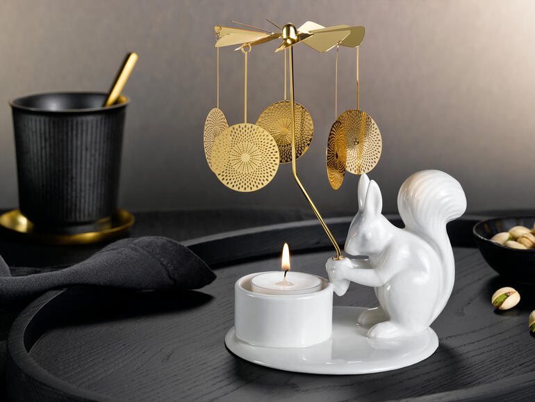 Carrousel à bougie avec un écureuil tenant une bougie sur une table élégante.