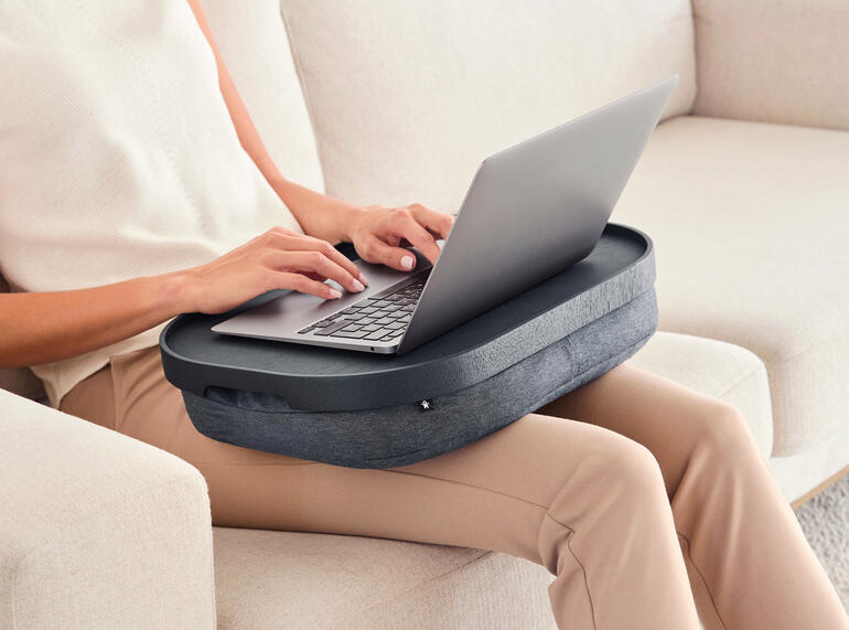Coussin antidérapant pour ordinateur portable avec plateau, tenu sur les genoux.