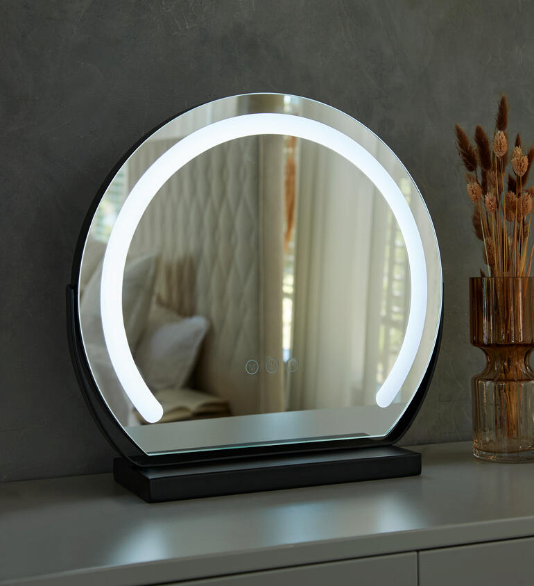 Miroir de maquillage rond avec éclairage, reflète l'environnement.