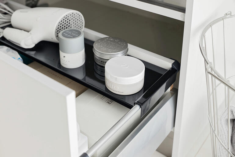 Insert de tiroir noir, équipé de produits cosmétiques et de soins