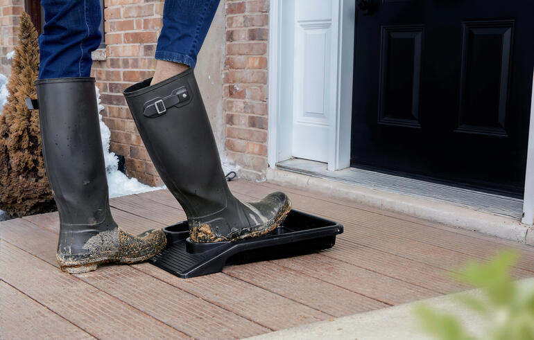 Personne debout sur un repose-chaussures avec des bottes