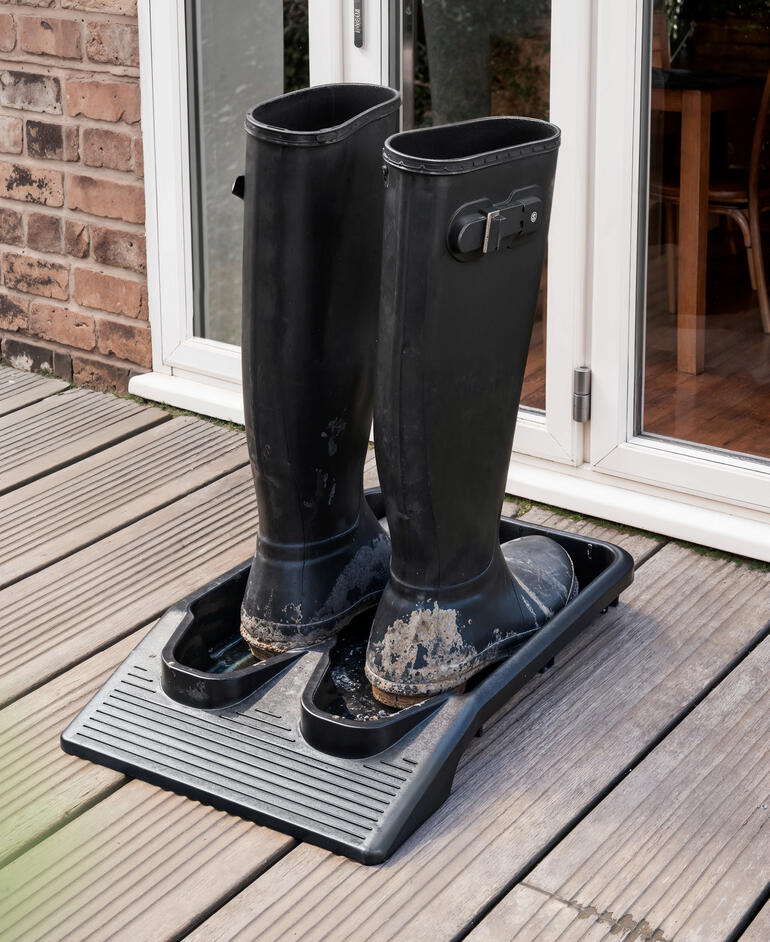 Bottes en caoutchouc sur un repose-chaussures