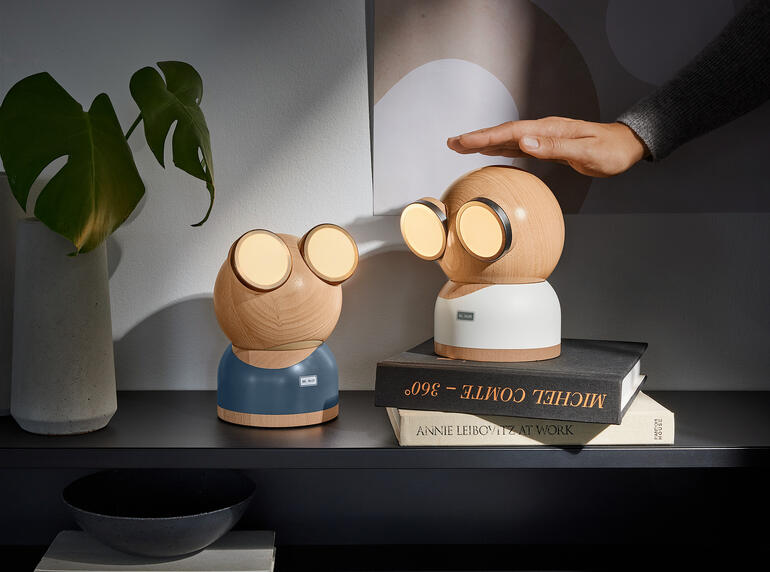 Deux lampes de designer Mr. Watt sur une table avec un livre.