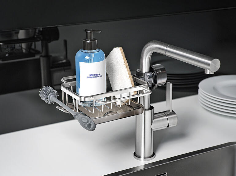 Organisateur d'évier avec bouteille et éponge sur l'évier.