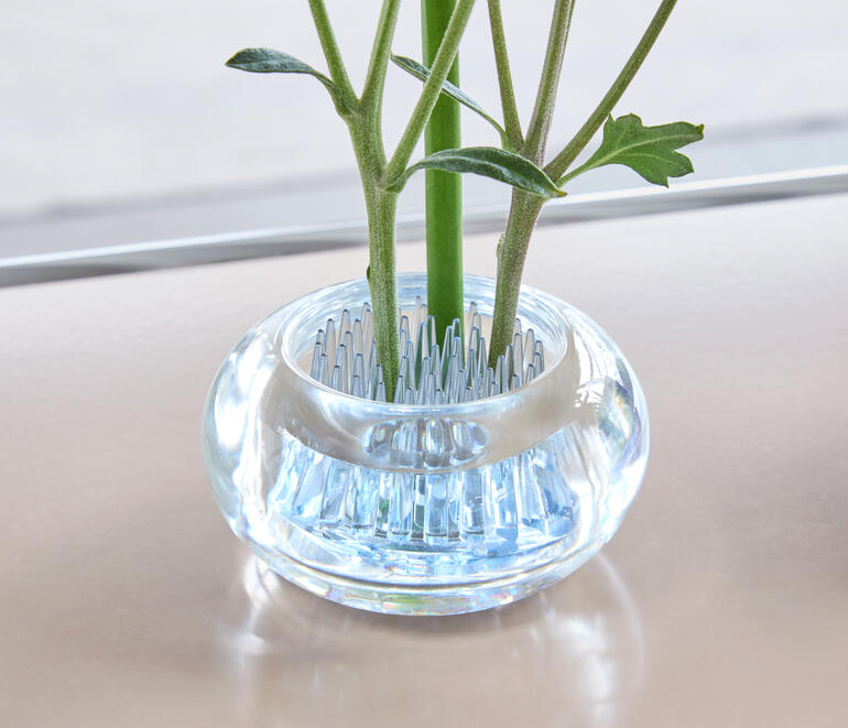 Vue détaillée d'un mini-vase avec des fleurs fixées.