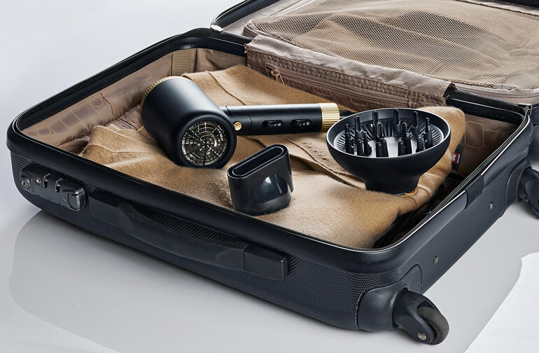 Sèche-cheveux de voyage compact dans une valise, avec accessoires.