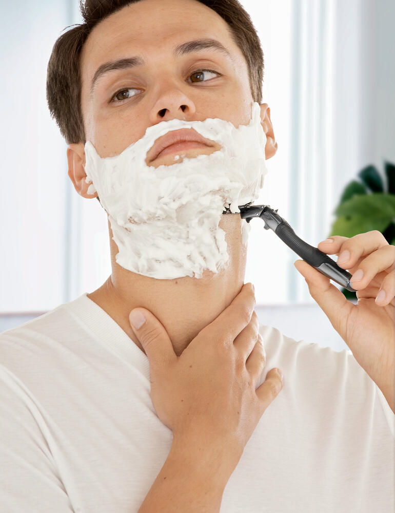 Homme avec de la mousse à raser sur le visage utilisant un rasoir 3D Flex.