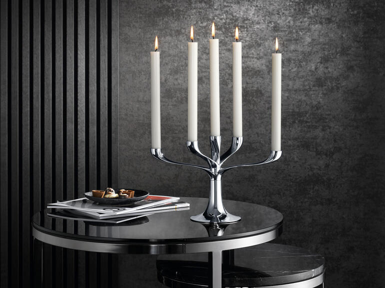 Candelabre moderne avec cinq bougies sur une table, décoration élégante.