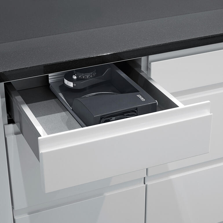 Avec seulement 8 cm de largeur, le trancheur ultra-compact se range même dans un tiroir de cuisine. Trancheuse ultracompacte dans un tiroir ouvert.