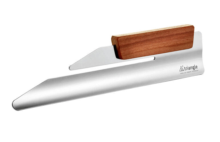 Ramasse-miettes design en acier inoxydable et bois sur un fond neutre.