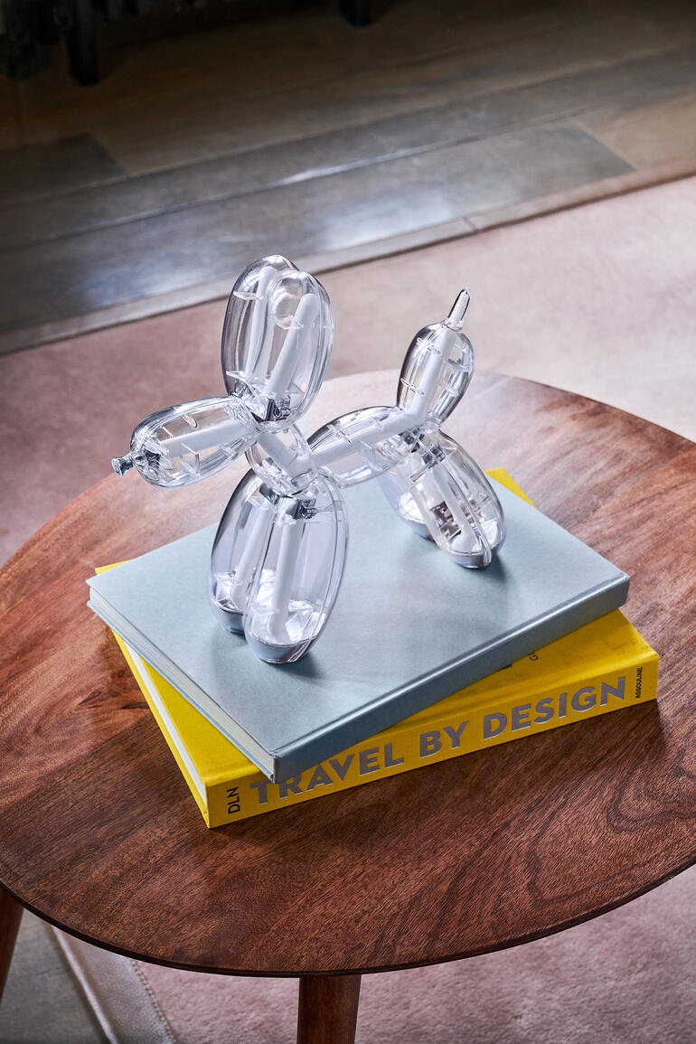 Lampe Balloon Dog en matériau transparent sur une table.