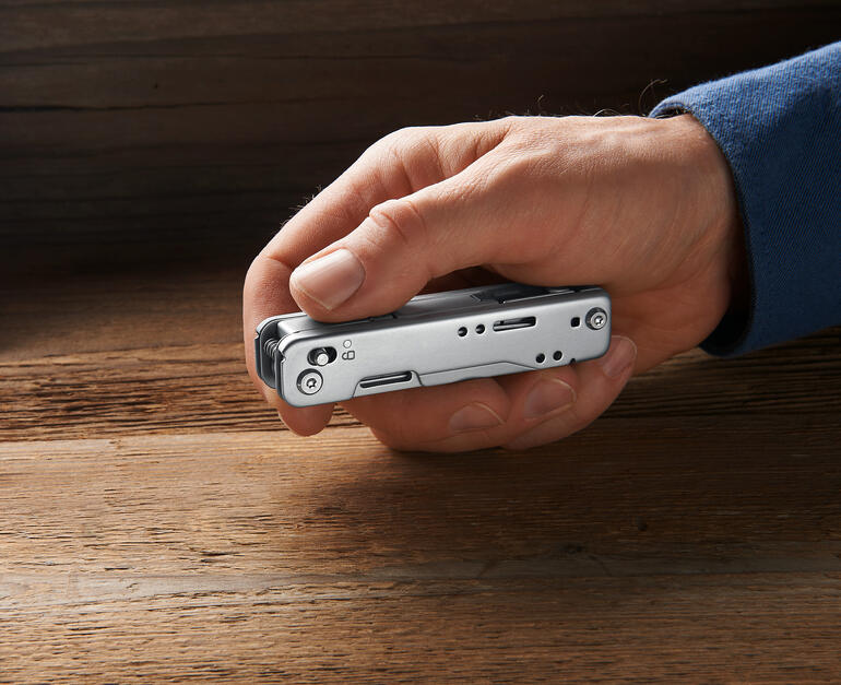 Outil polyalent 12-en-1 Main tenant un outil multifonction compact 12-en-1 avec des outils repliés.