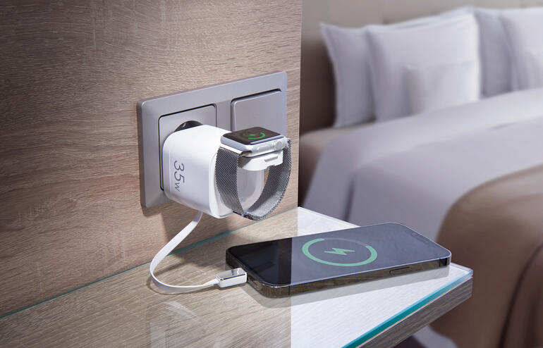 Chargeur rapide chargeant simultanément un smartphone et une smartwatch dans un environnement hôtelier.