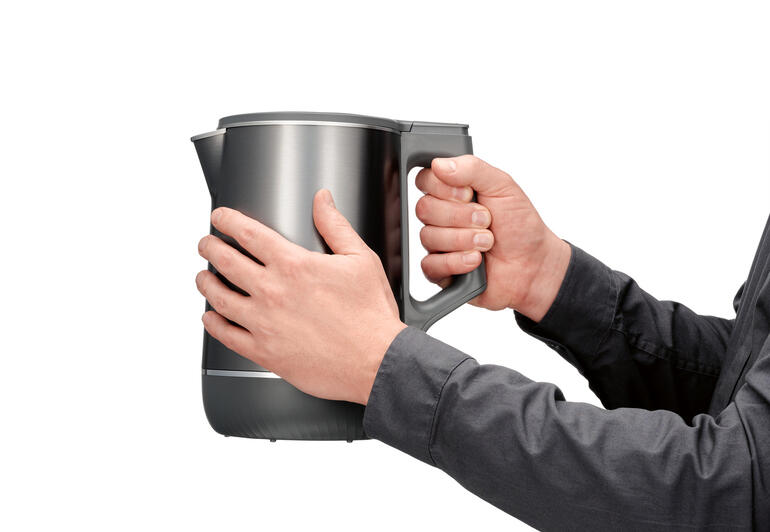 Utilisateur tenant la bouilloire double avec le système de chauffage 3D.