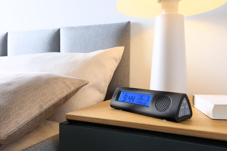 Réveil radio avec lampe de poche LED sur la table de nuit à côté du lit