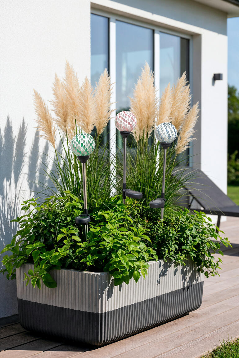 Piquets solaires dans une jardinière de balcon avec des herbes ornementales.