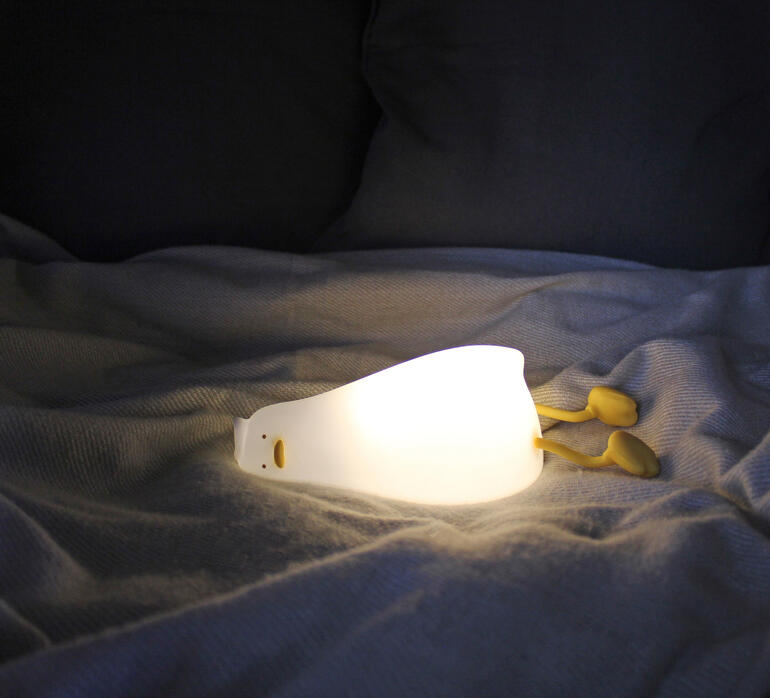 Lampe de nuit canard fatigué s'illumine sur un lit.