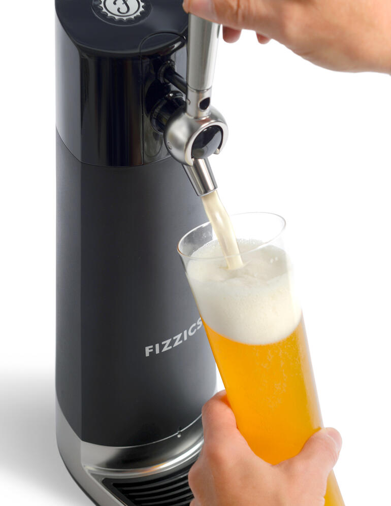 Mains tirant de la bière du tireuse à bière dans un verre.