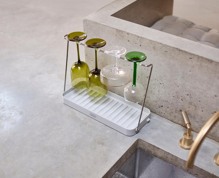 Supports de séchage de verres à vin avec plusieurs verres sur un comptoir.