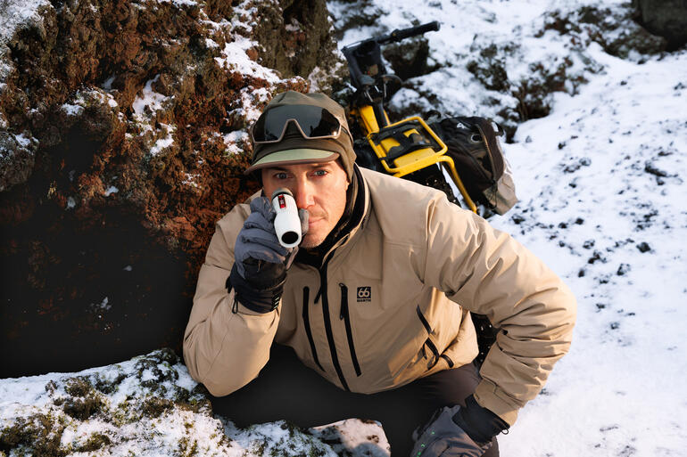 Homme observant avec un monoculaire dans les montagnes pendant la neige.