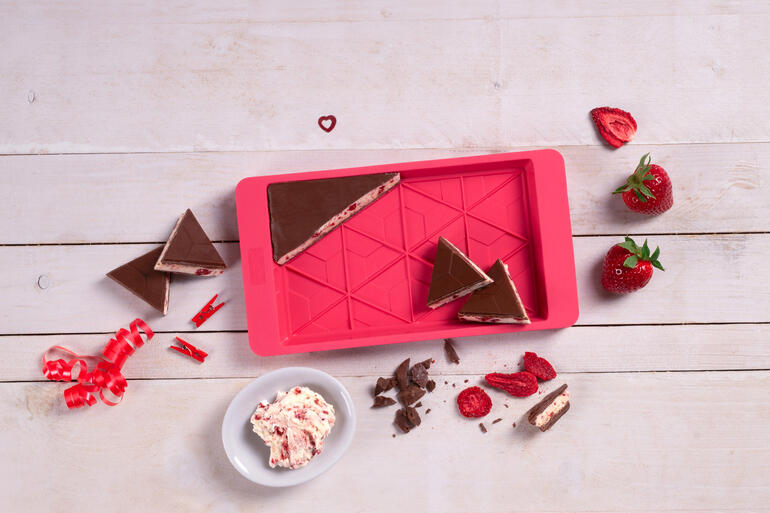 Moule en silicone en forme de chocolat avec des cœurs et des fraises.