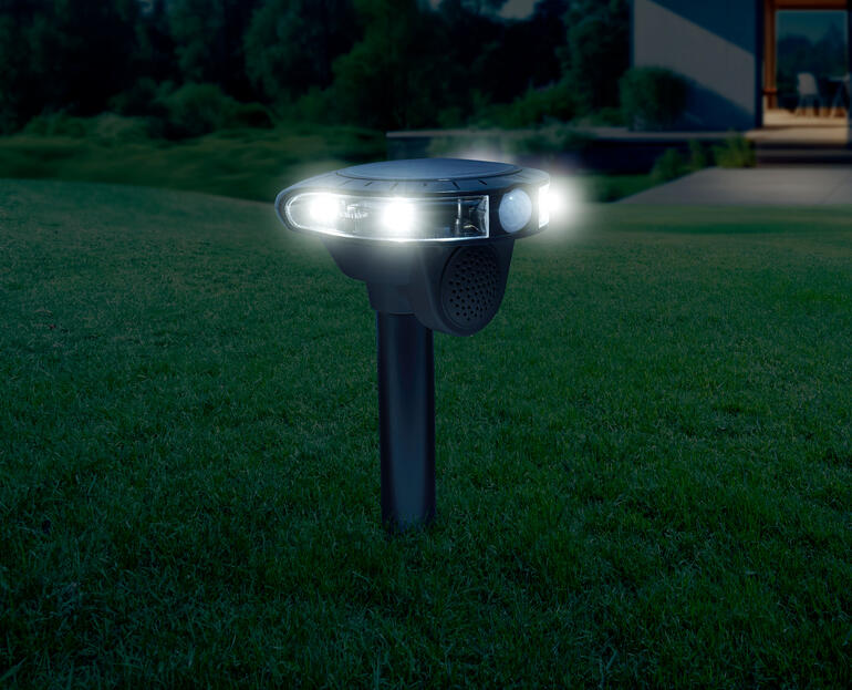 Système de lutte contre les animaux électroniques la nuit, éclairé par deux lampes blanches.