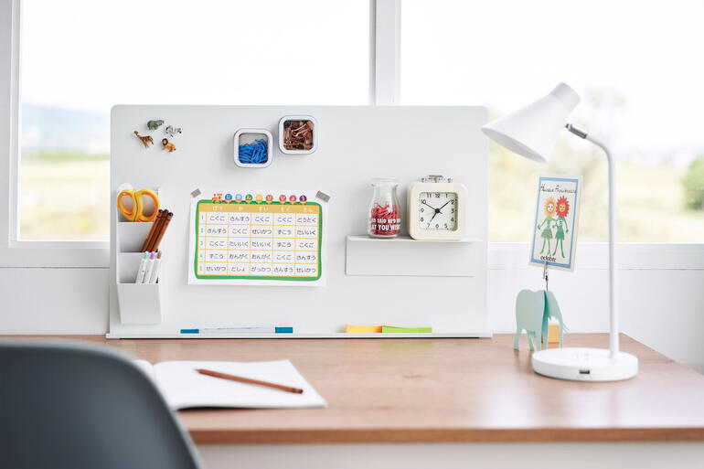 Tableau magnétique blanc avec fournitures de bureau sur un bureau.