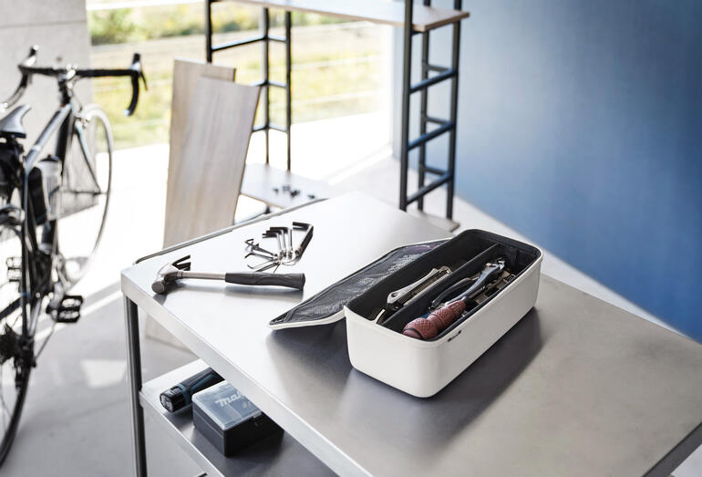 Boîte à outils sur une table avec des outils en arrière-plan.