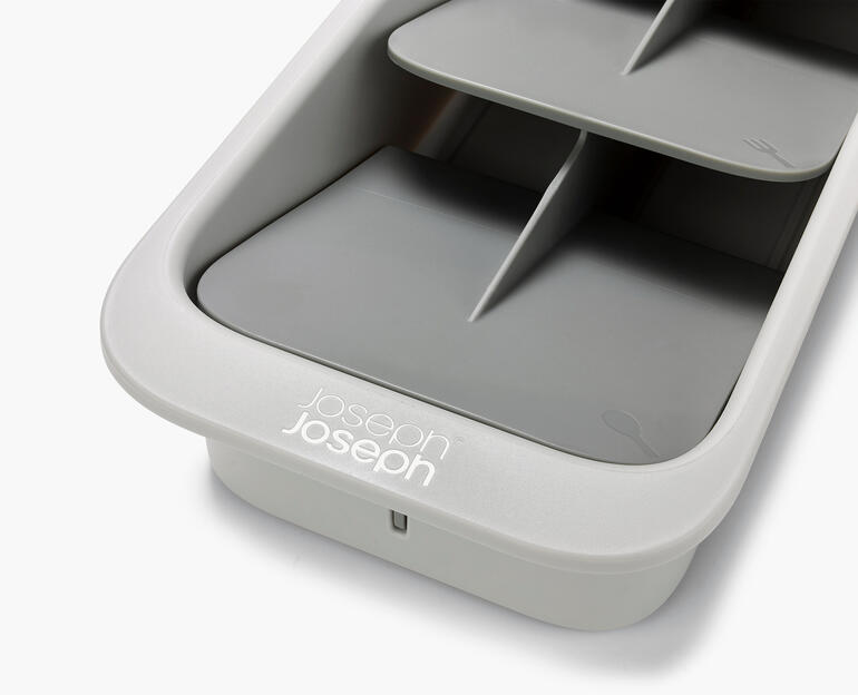 Gros plan d'un organiseur de couverts compact en gris.