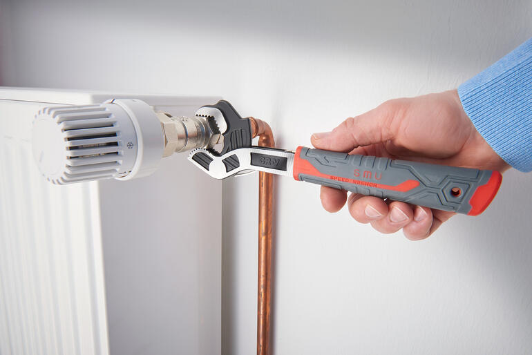 Clé à molette utilisée pour visser une vanne de radiateur.