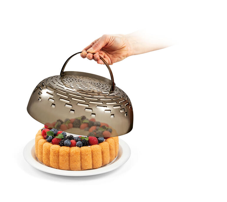 Main soulevant un couvercle amovible d'un bol 3 en 1 avec des fruits